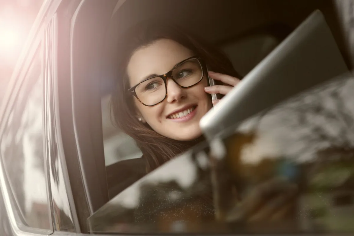 Driver on the phone in a car getting an insurance quote
